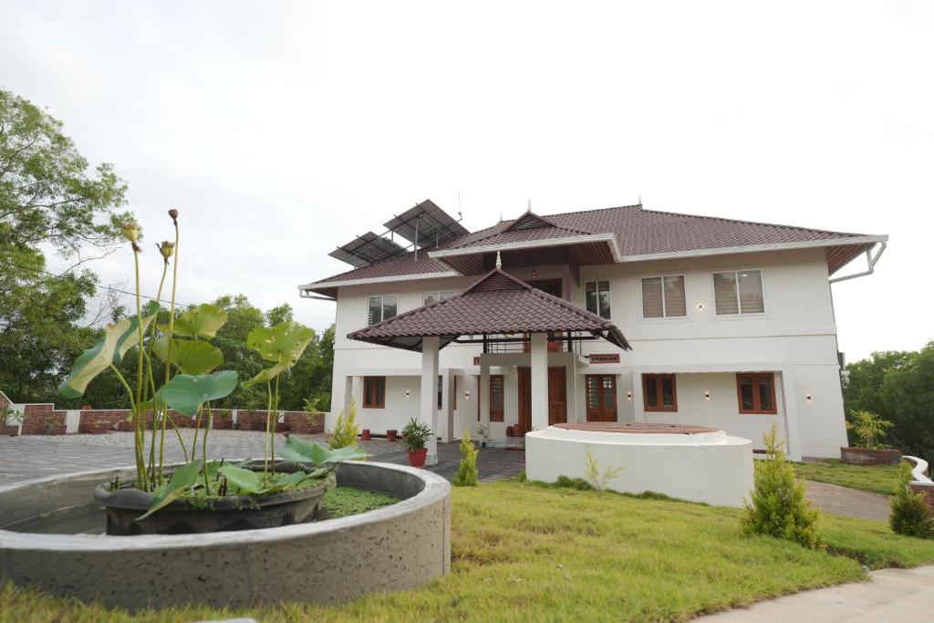 a house with a fountain in front of it at Winspark Inn Resort in Varkala