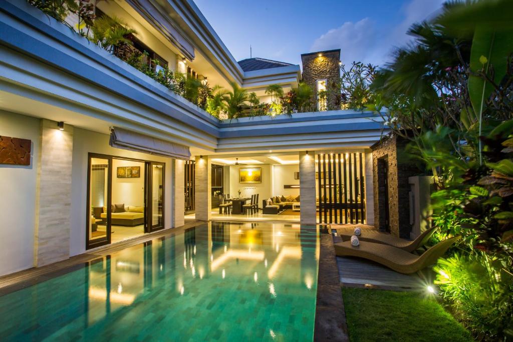 une villa avec une piscine la nuit dans l'établissement The Amarta Villa, à Jimbaran