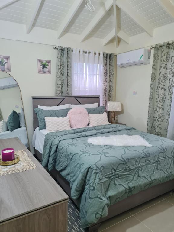 a bedroom with a large bed and a mirror at Home to Comfort in Old Harbour