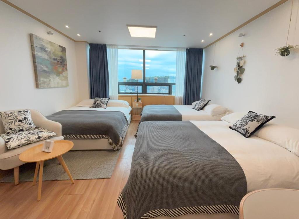 a hotel room with three beds and a window at Hongdae sub 1min in Seoul