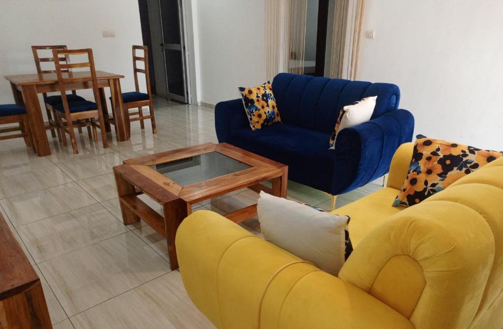 Appartement 3 pièces Tout Confort Calme - Colibri في ياموسوكرو: غرفة معيشة مع أريكة صفراء وطاولة