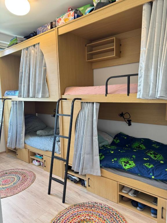 a bunk bed room with two bunk beds and a ladder at AECOspires CoWorkStel in Munich