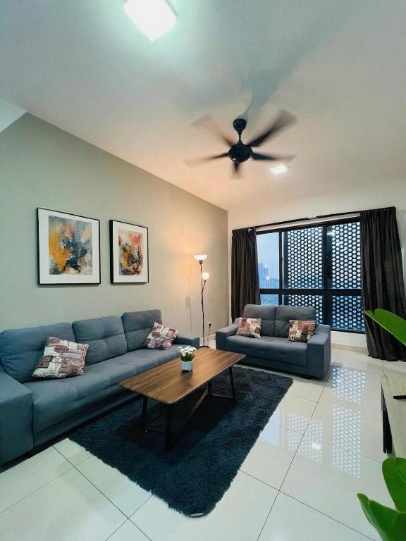 a living room with a blue couch and a ceiling fan at Spacious 3B3R Unit in BukitJalil in Kuala Lumpur