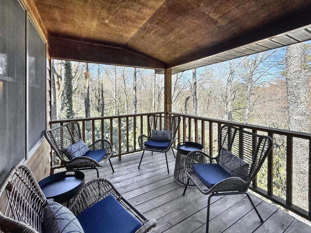 a screened in porch with chairs and tables at The Spotted Owl in Highlands