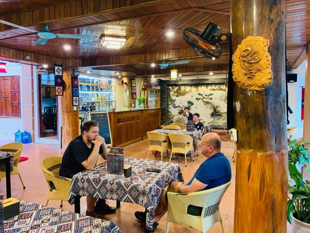 マイチャウにあるMai Ha Backpackers Hostel & Garden Loungeのレストランの席に座る男たち