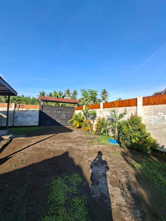 der Schatten einer Person, die in einem Hof steht in der Unterkunft Penempuran cottage in Masbagik