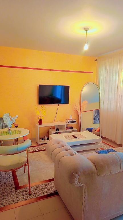 a living room with couches and a flat screen tv at Bustani Homes apartment in Kahawa