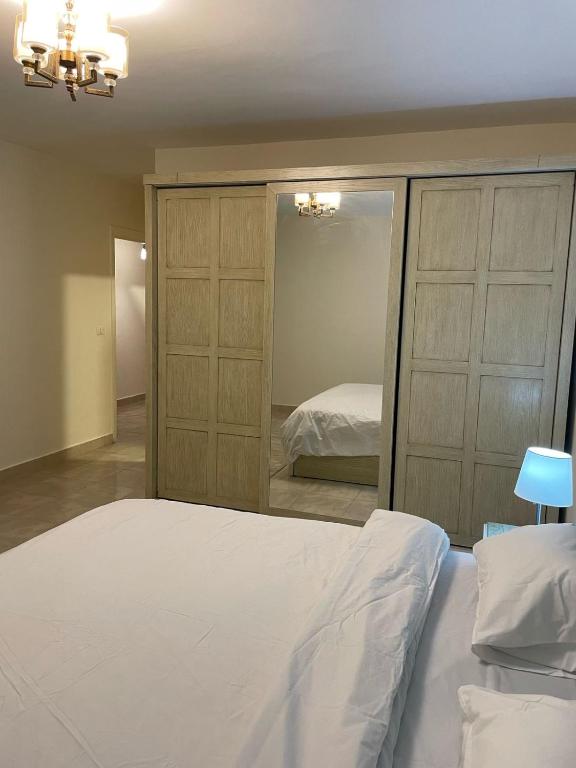 une chambre avec un lit et un grand miroir dans l'établissement شقة فاخرة, à Madinaty
