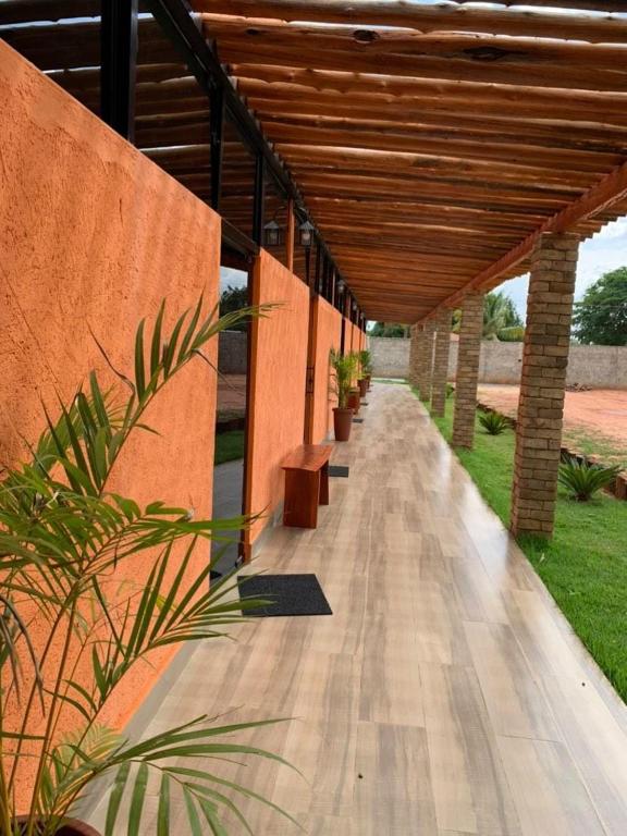 a covered walkway with benches under a wooden roof at Pousada Jalapão Sunset in Mateiros