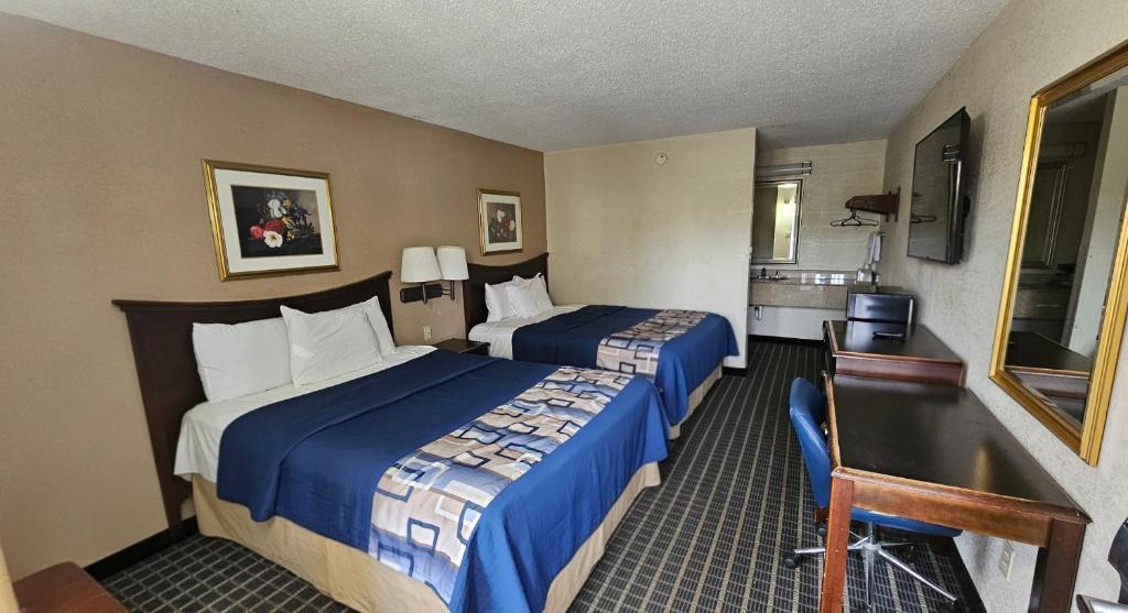 a hotel room with two beds and a desk at Americas Best Value Inn Mount Vernon in Mount Vernon