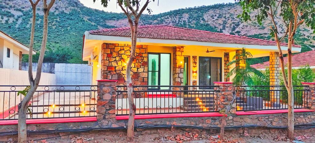 una casa amarilla con una valla delante en Girivan, en Alwar