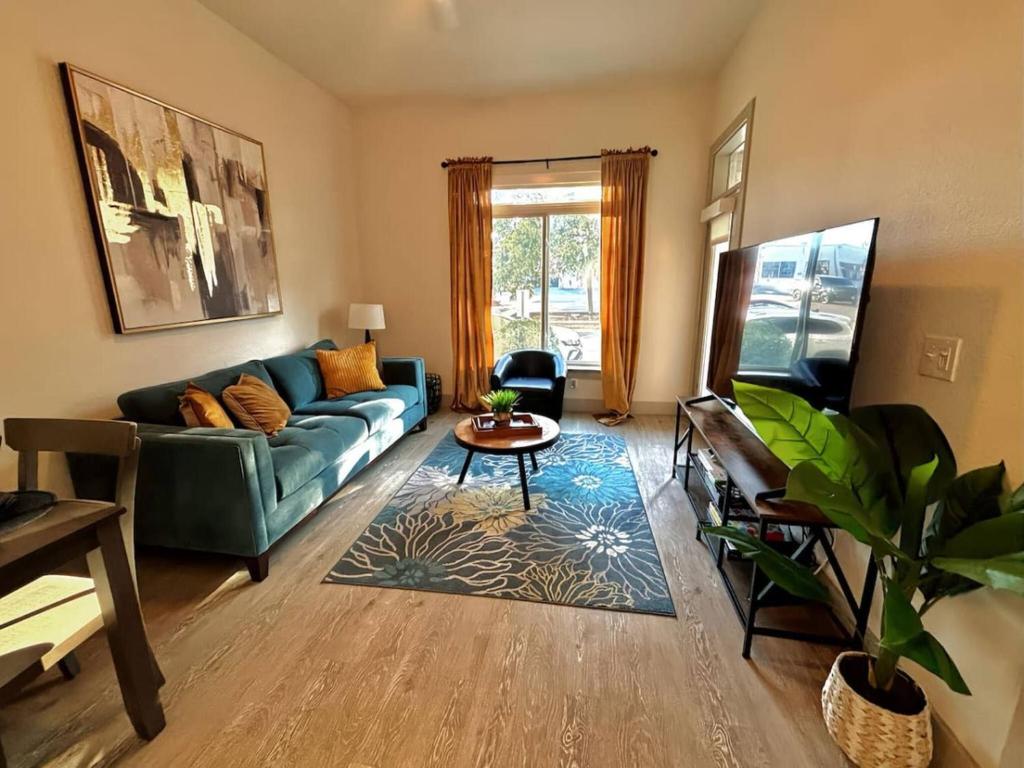 ein Wohnzimmer mit einem blauen Sofa und einem Tisch in der Unterkunft Riverwalk Luxury Haven Pool Free Parking in San Antonio