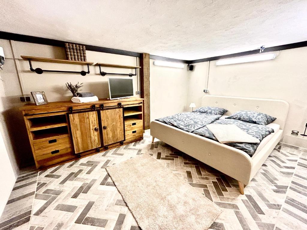 a bedroom with a bed and a dresser and a television at Bramasole - Wohnung mit Carport in Cottbus