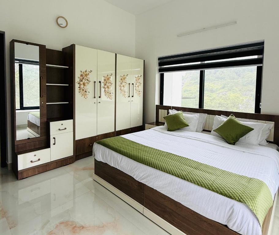 a bedroom with a large bed and some windows at KiwiOz Villa in Thamarassery