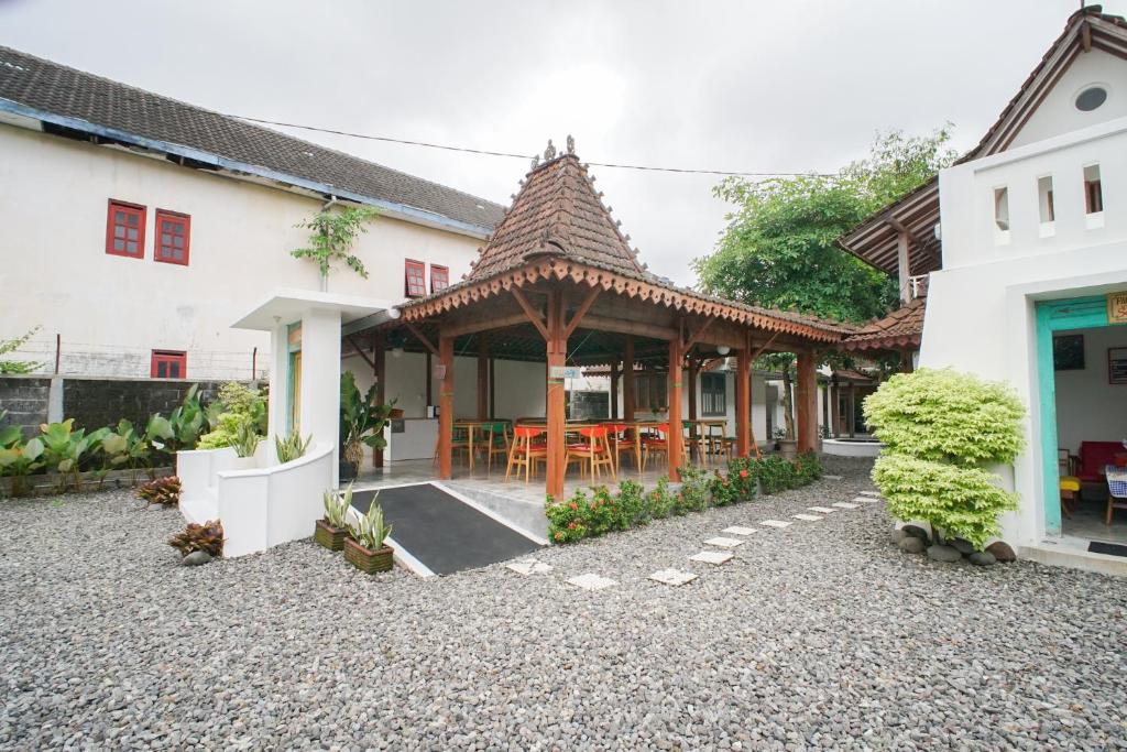 une maison avec un pavillon en bois dans une cour dans l'établissement Pilar Guest House Jogja, à Ngemplak
