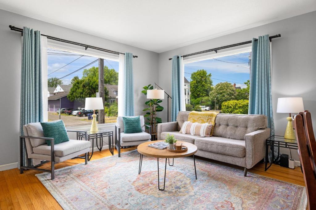 a living room with a couch and chairs and windows at Walk to Dining & Waterfront, Spacious with Best Beds in Tacoma