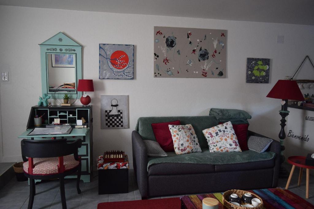 a living room with a green couch and a desk at Gite le GINKGO 50 M2 in Rougegoutte