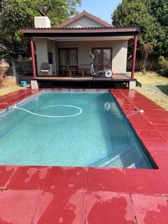 a pool with a basketball hoop in front of a house at Tucked away with a pool view in White River