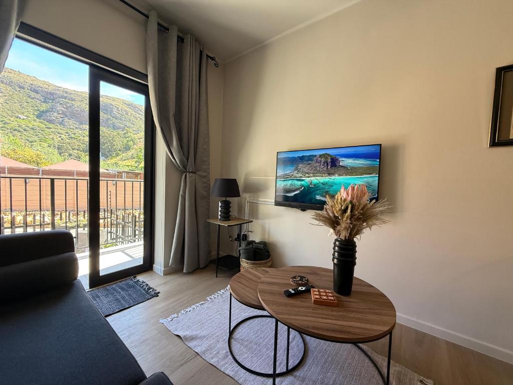 サイモンズタウンにあるMountain Bay Apartment with Sea and Mountain Viewsのテーブルとテレビのあるリビングルーム