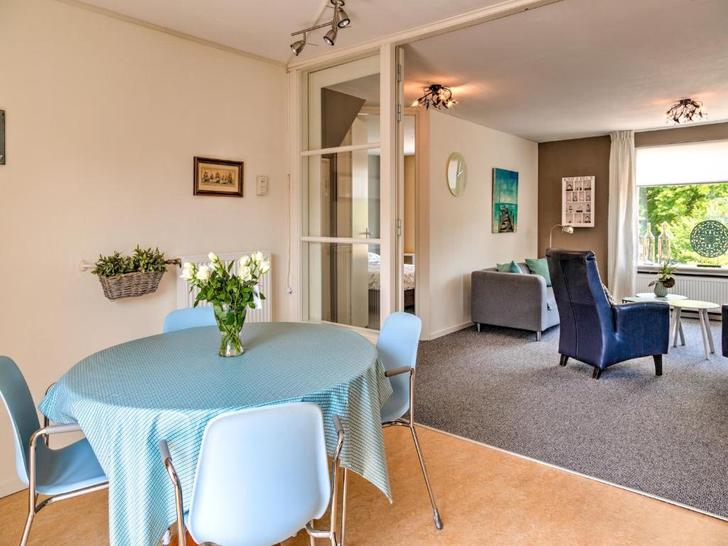 a dining room with a blue table and chairs at Stunning apartment in Schoorl, North Hollandâ you can bike to the beach in Schoorl