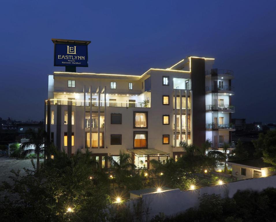 リシケーシュにあるEastlynn Resort Rishikeshの夜に屋根の上に看板が立っている建物