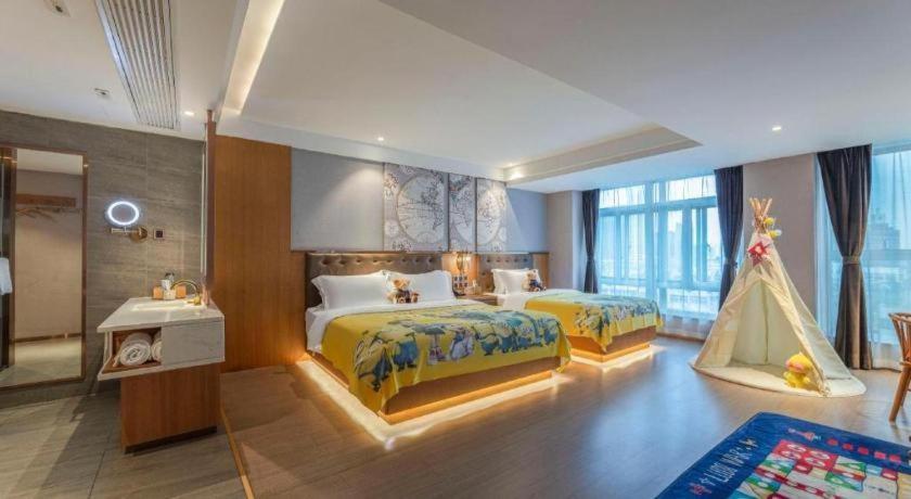 een slaapkamer met 2 bedden en een speeltent bij James Joyce Coffetel Hefei University of Technology in Hefei