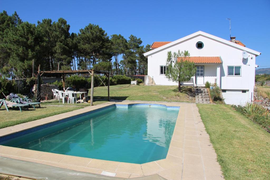 una piscina di fronte a una casa di Quinta dos Gata a Nabainhos