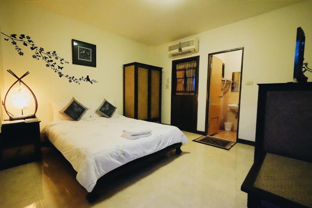 清邁的住宿－โรงแรมตีฆ้อง - Tri Gong Hotel，卧室配有白色的床和镜子