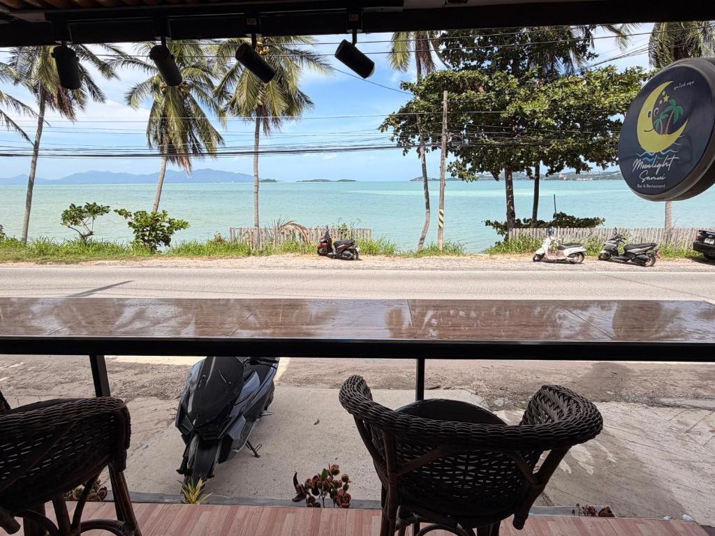 a view of a beach with chairs and the ocean at Moonlight Samui hotel and bar in Koh Samui 