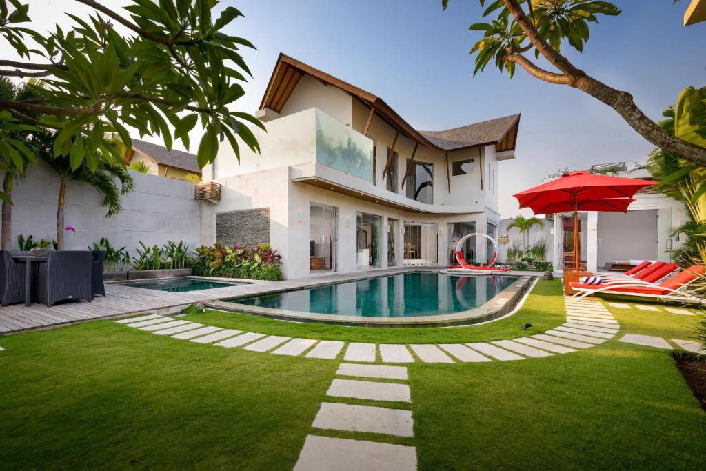 a villa with a swimming pool and a house at Villa Miro in Seminyak