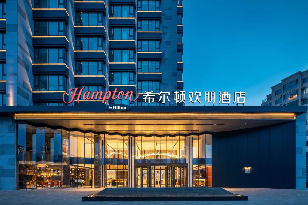een hotel met een bord op de voorgevel van een gebouw bij Hilton Garden Inn Chengde Mountain Resort in Niuquanzigou