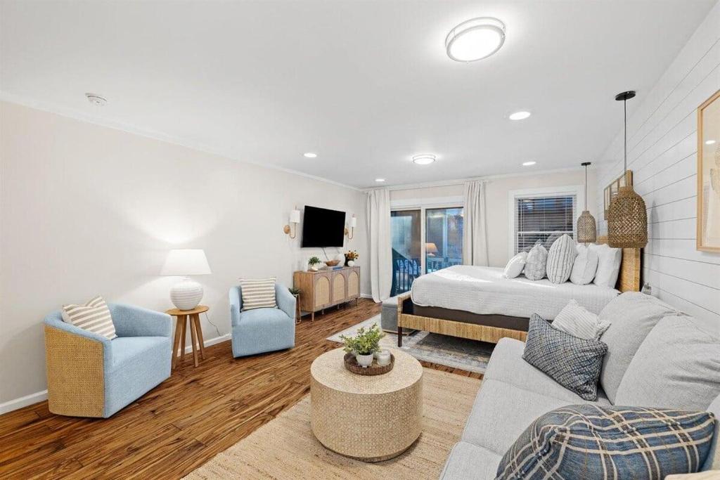 a bedroom with a bed and a couch and chairs at Grandy 30A in Inlet Beach