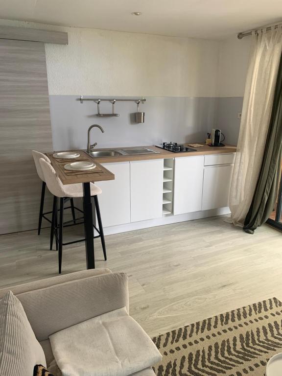 Una sala de estar con una mesa y una cocina. en L horizon, en Ravine des Cabris