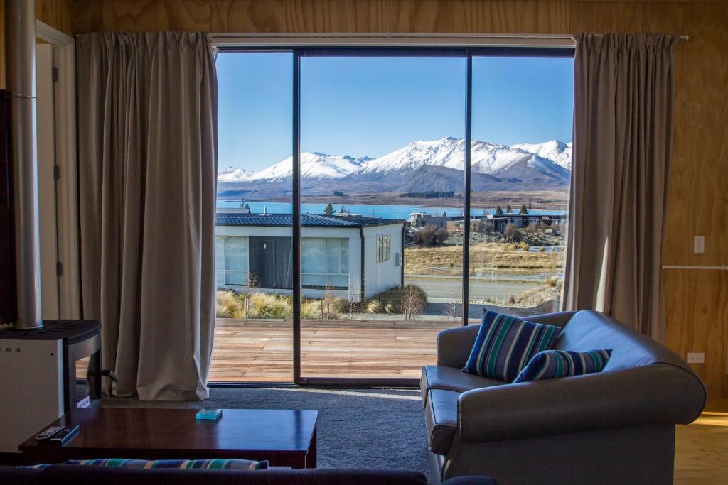 a living room with a couch and a large window at Nordic Escape - Lake Tekapo in Lake Tekapo