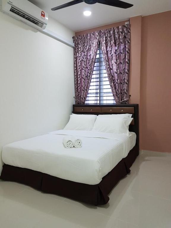 Schlafzimmer mit einem großen Bett und einem Fenster in der Unterkunft Ummi Guesthouse in Dungun