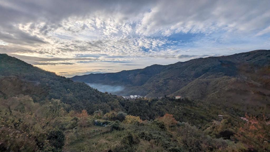 The quiet yellow house في Pornassio: اطلاله على وادي جبلي اشجار وغيوم