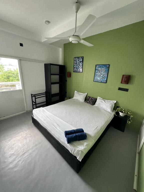 a bedroom with a large bed with a ceiling fan at The Reef Weligama in Weligama