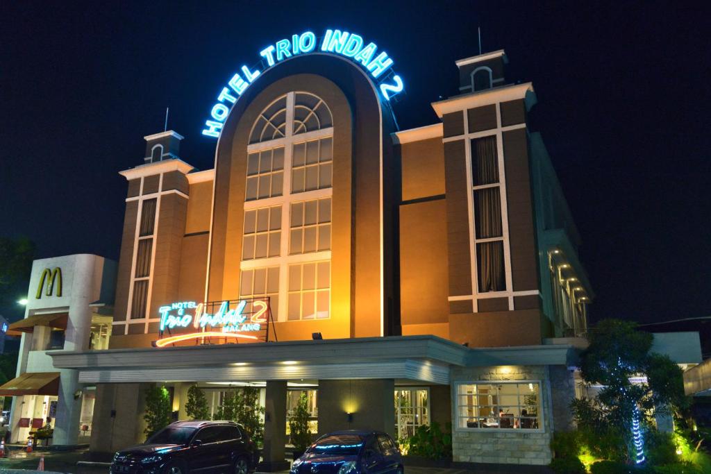 a building with a neon sign on top of it at Hotel Trio Indah 2 in Malang