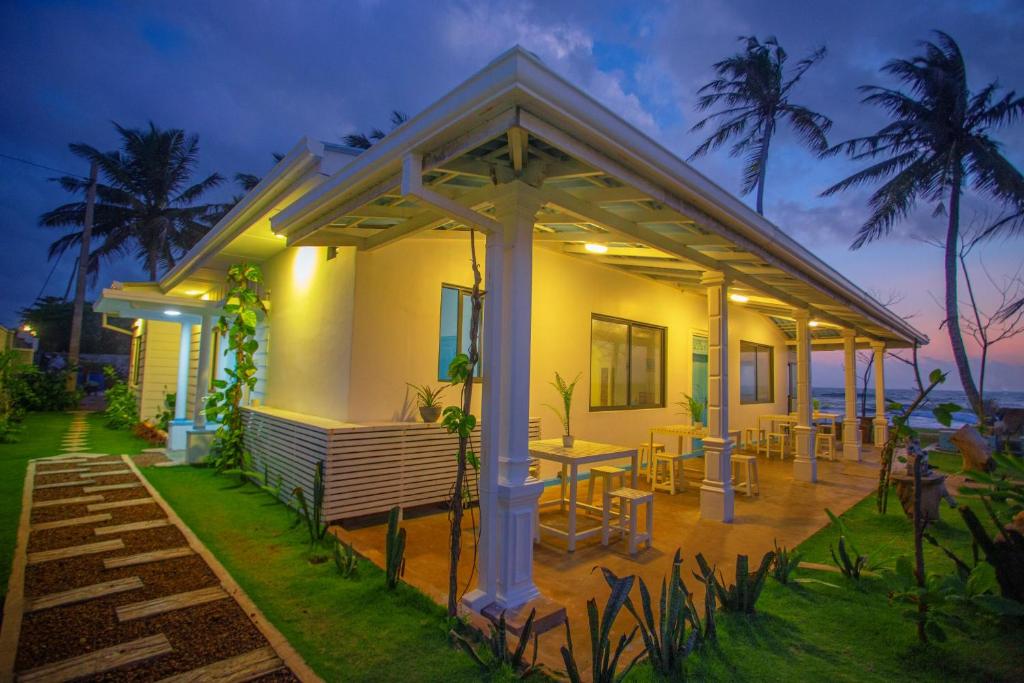 a house with a table and chairs in front of it at Villa Amor by the Beach in Ambalangoda