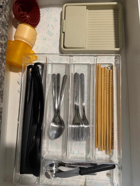 a plastic container with utensils in a drawer at Maple Grove Yasuragi Stay in General Trias