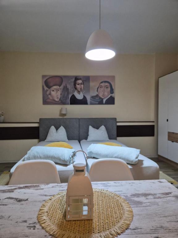 a bedroom with two beds and a table with a jug on it at Centar Novi Sad Studio No2 PARKING ON REQUEST in Novi Sad