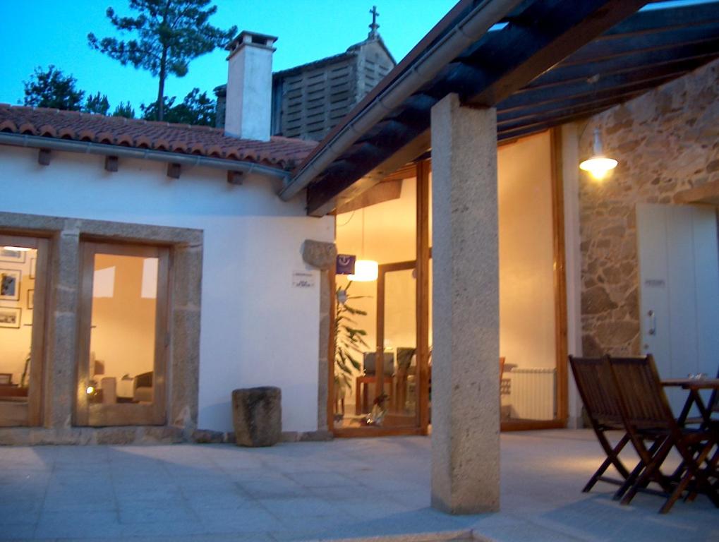 a house with a patio with a table and chairs at Casa do Fieiro in Miñortos