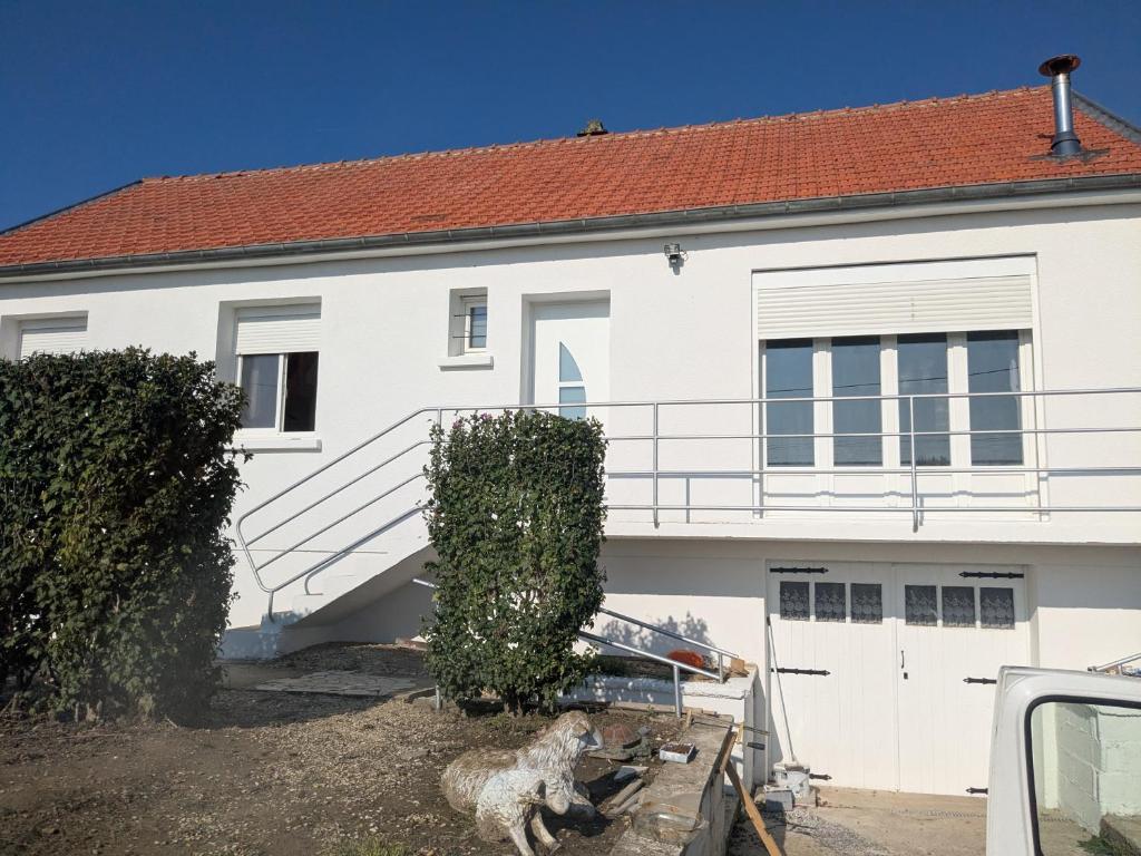 ein weißes Haus mit einer Treppe und einem Auto vor dem Haus in der Unterkunft La Casa Blanca 