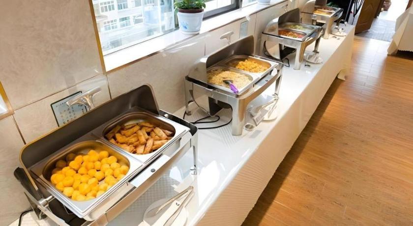 een buffet met veel schalen met sinaasappels en ander eten bij GreenTree Inn Maanshan Hanshan District Jiuwu Square Hotel in Jiulian