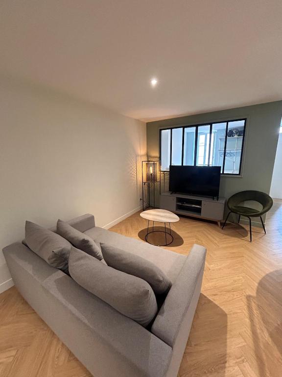 a living room with a couch and a flat screen tv at Le scandinave in Pont-de-Veyle