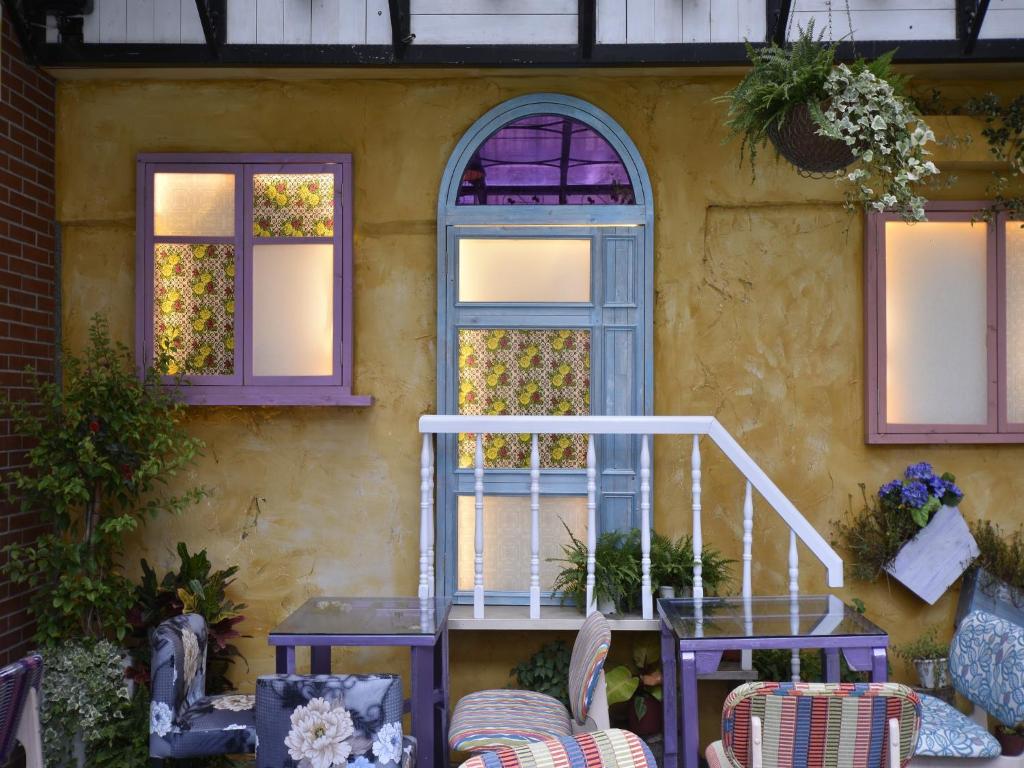 a house with a staircase and a table and windows at DG Hotel in Taipei