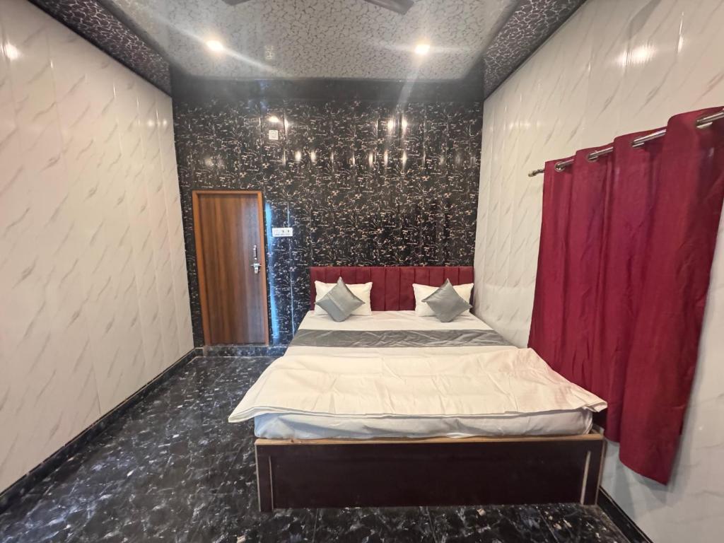 a bedroom with a bed and a red curtain at Rita Shree Homestay At Ayodhya Highway in Sultānpur