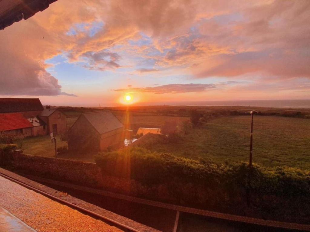 AudervilleにあるChambre phareの空の日が沈む畑の夕日