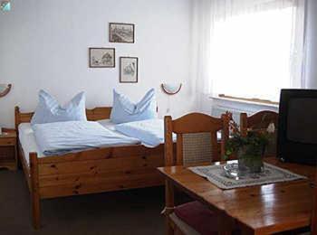 Zimmer mit einem Bett, einem Tisch und einem TV in der Unterkunft Hotel Urbanus in Heilbronn
