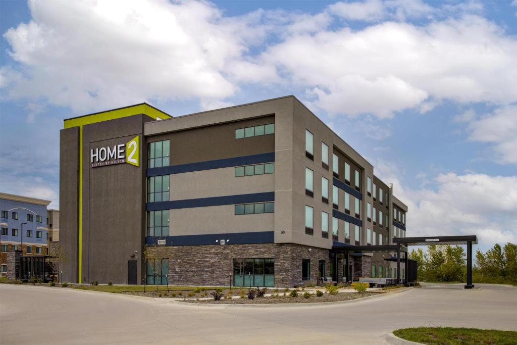 un gran edificio de oficinas con un cartel. en Home2 Suites By Hilton Ames, en Ames